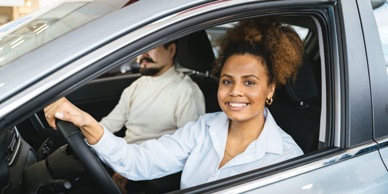 woman volunteer driving a car with a passenger