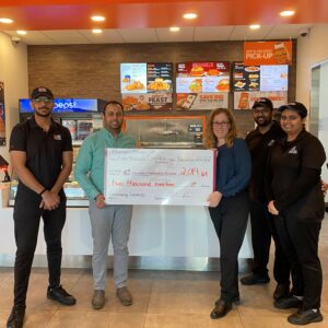 group of people holding a large cheque