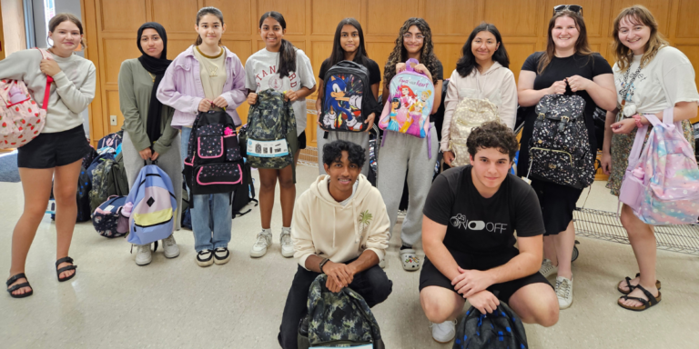 photo of youth volunteers holding backpacks